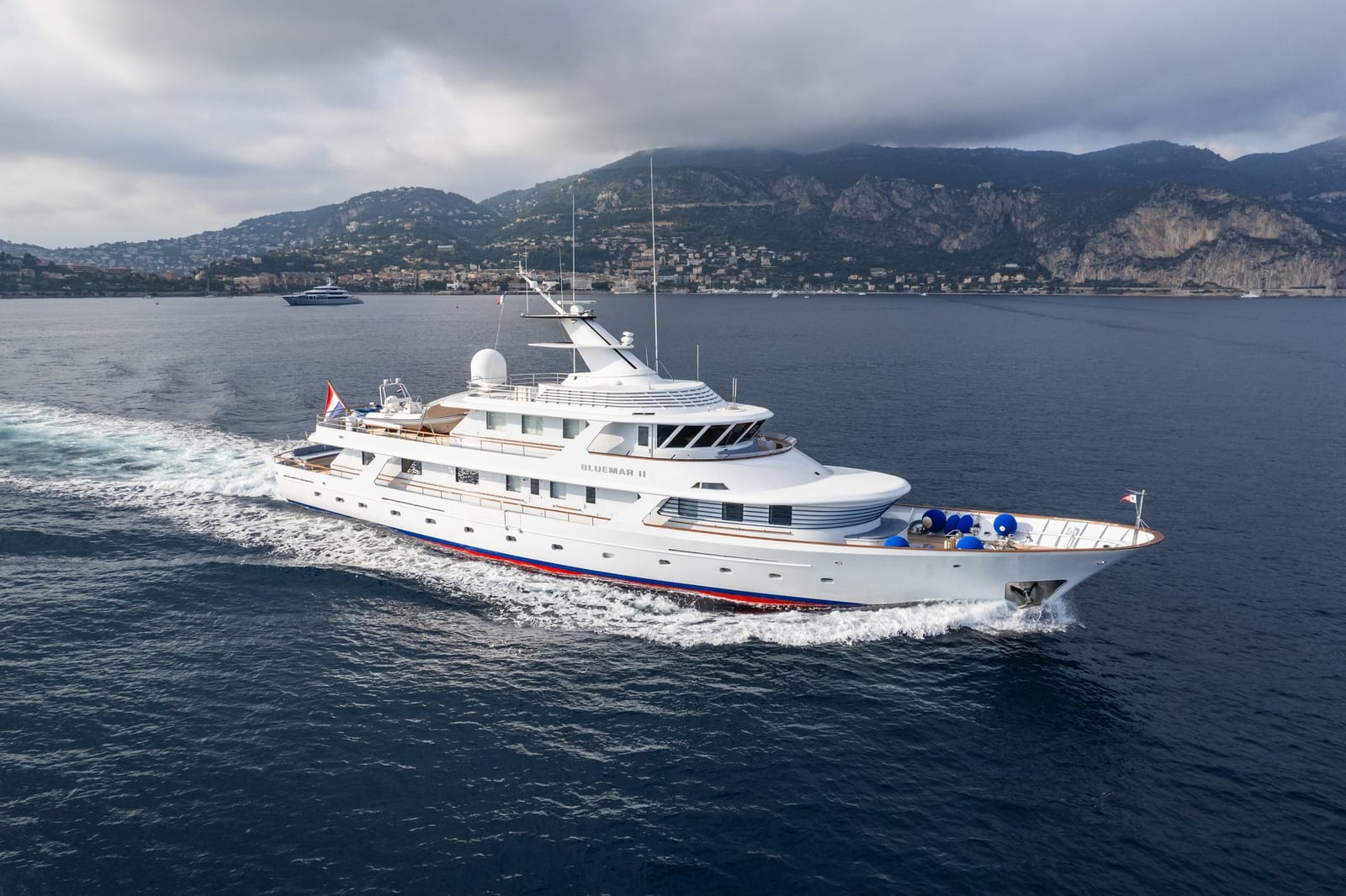 Bluemar II underway off the French Riviera under a heavy overcast sky, the white hull evenly lit
