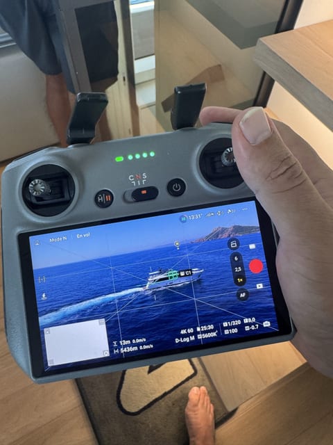 Drone controller showing a yacht underway
