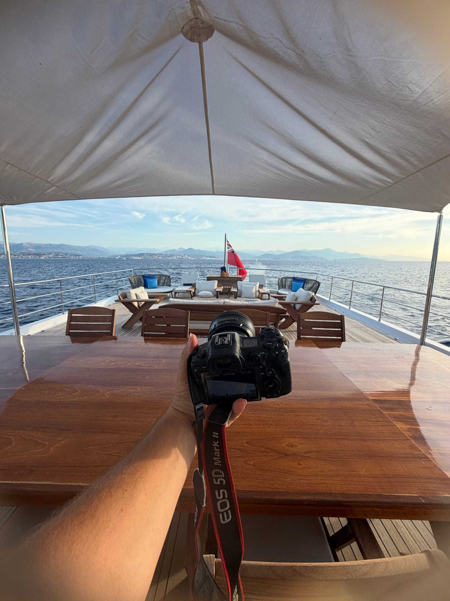 Photographer holding a camera above a styled aft deck table to frame the shot