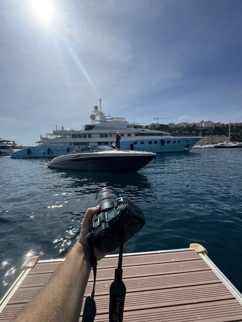 Camera held over the water from a tender beside a superyacht