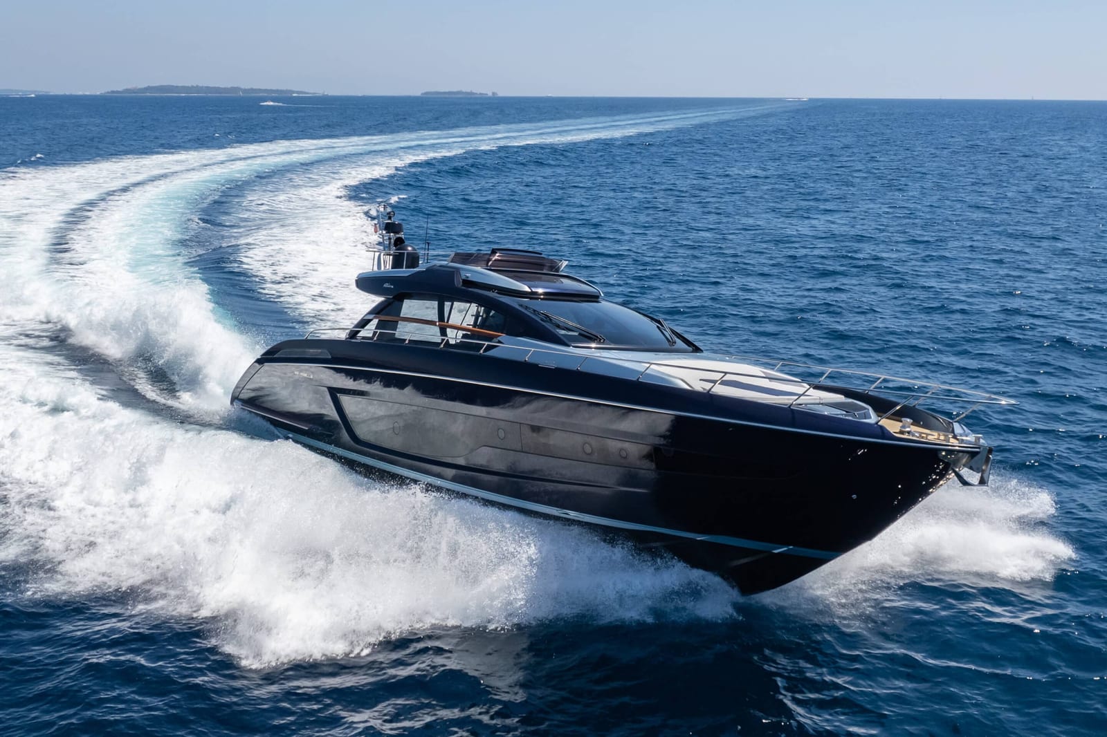 Dark-hulled motor yacht running at speed