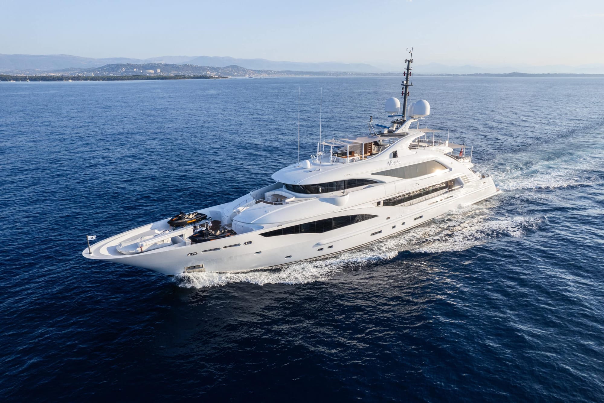 Superyacht underway on deep blue open water, seen from above