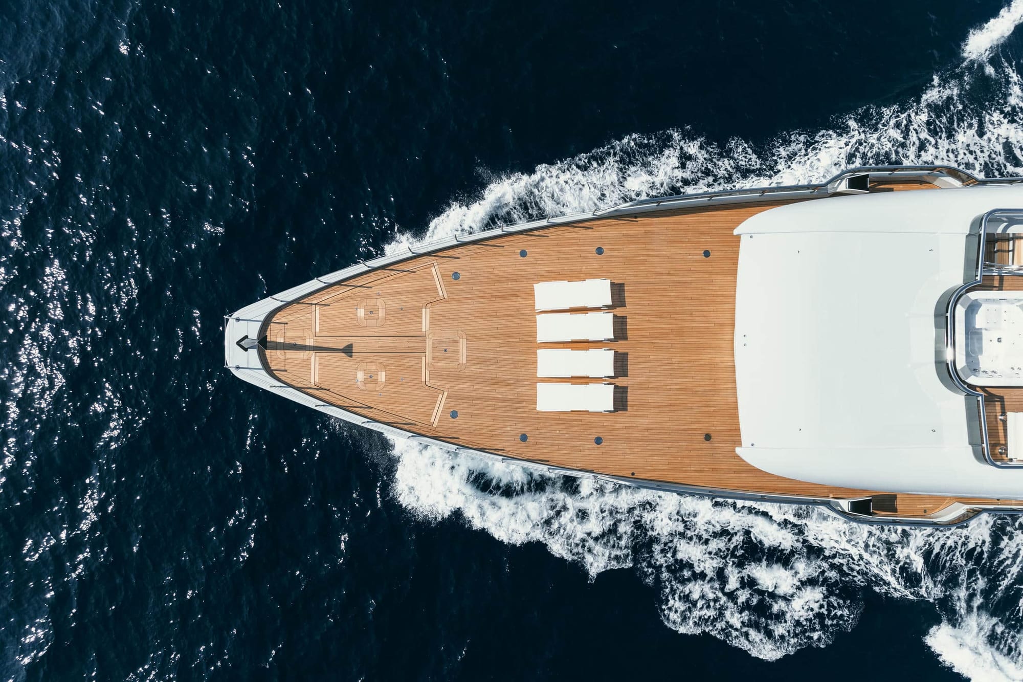 Aerial view looking down on the teak foredeck of a yacht underway