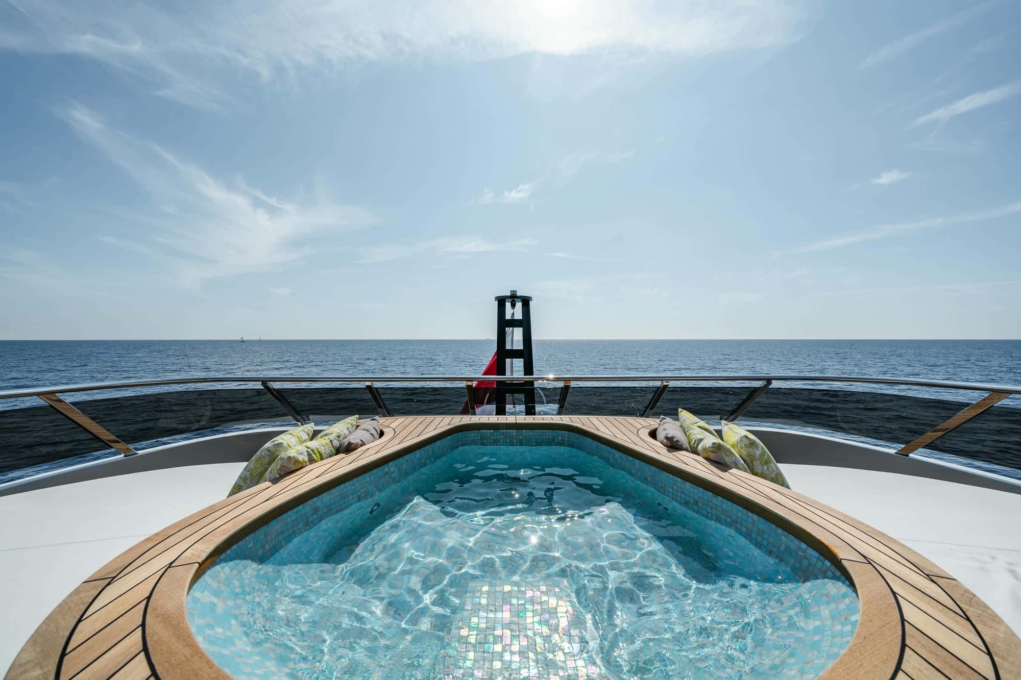 Bow deck jacuzzi on a superyacht with sun loungers and open sea behind