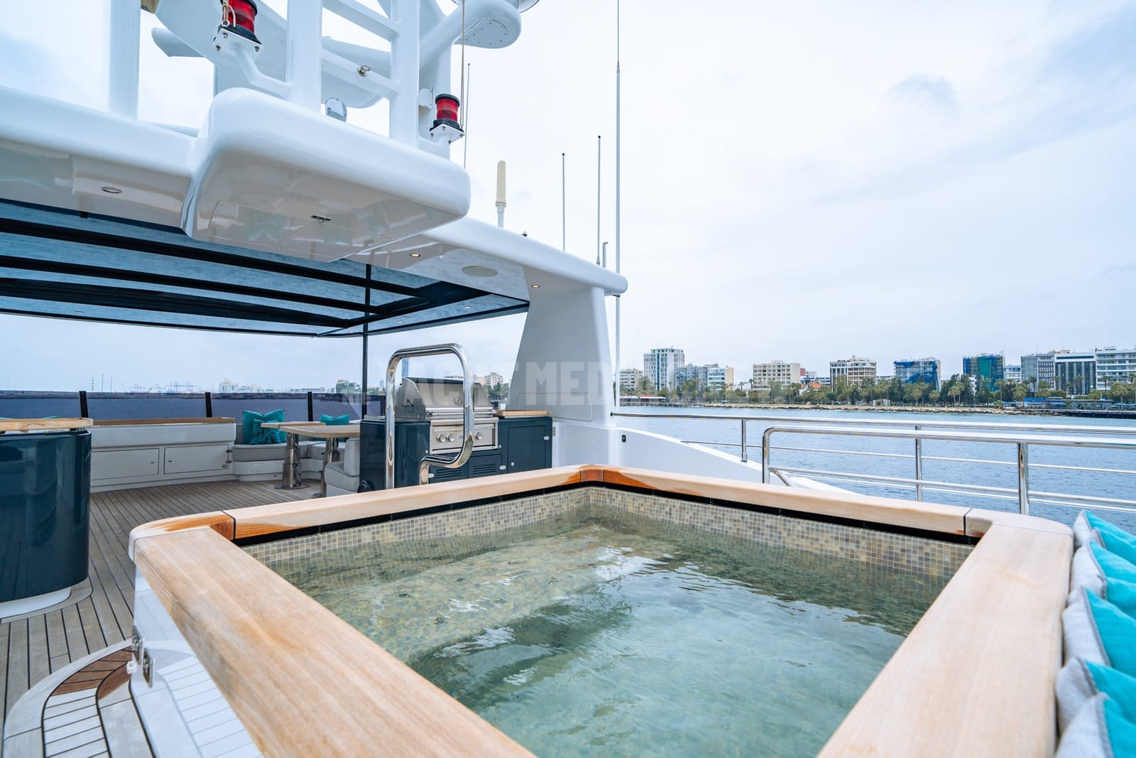 Wet deck and jacuzzi of the yacht Cape Cod II under an overcast sky