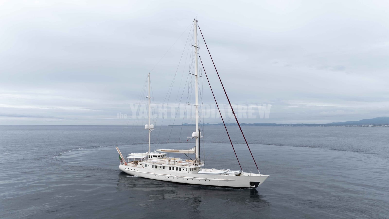 Sailing yacht Dione Star on a calm grey sea under a heavy sky, shot in the rain